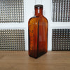 Grand flacon de médicament en verre moulé ambré des Laboratoires J.L. Châtelain - Hello Broc